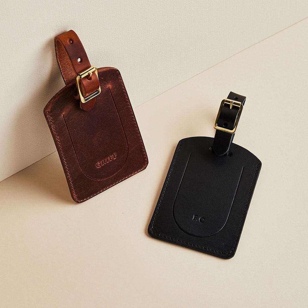Pair of leather luggage tags by Man & Bear, made in brown and black
