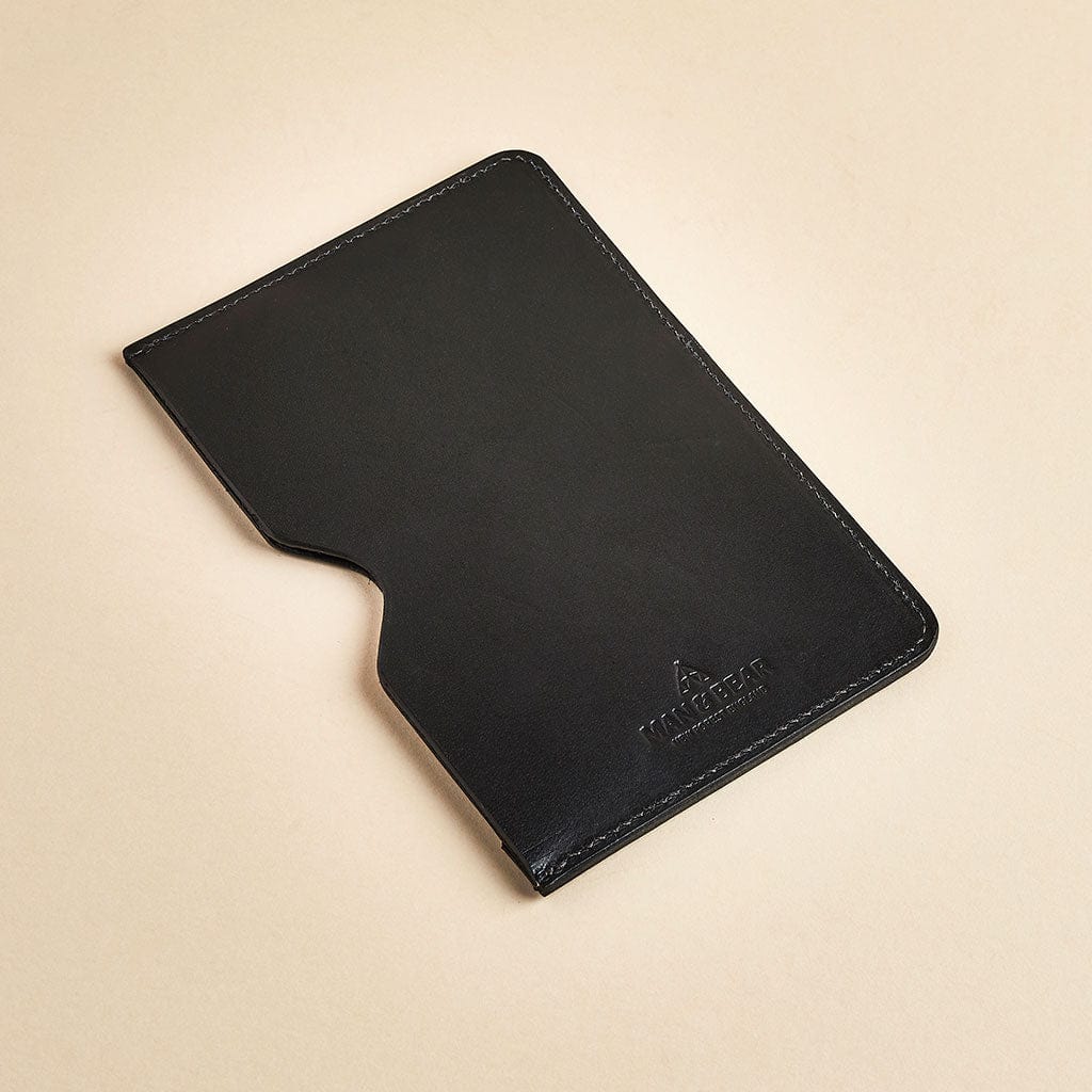 Black leather passport sleeve branded with the Man & Bear logo