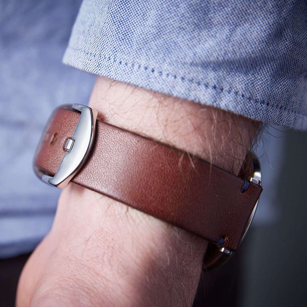 Men's wallet with brown leather strap, modelled on a wrist