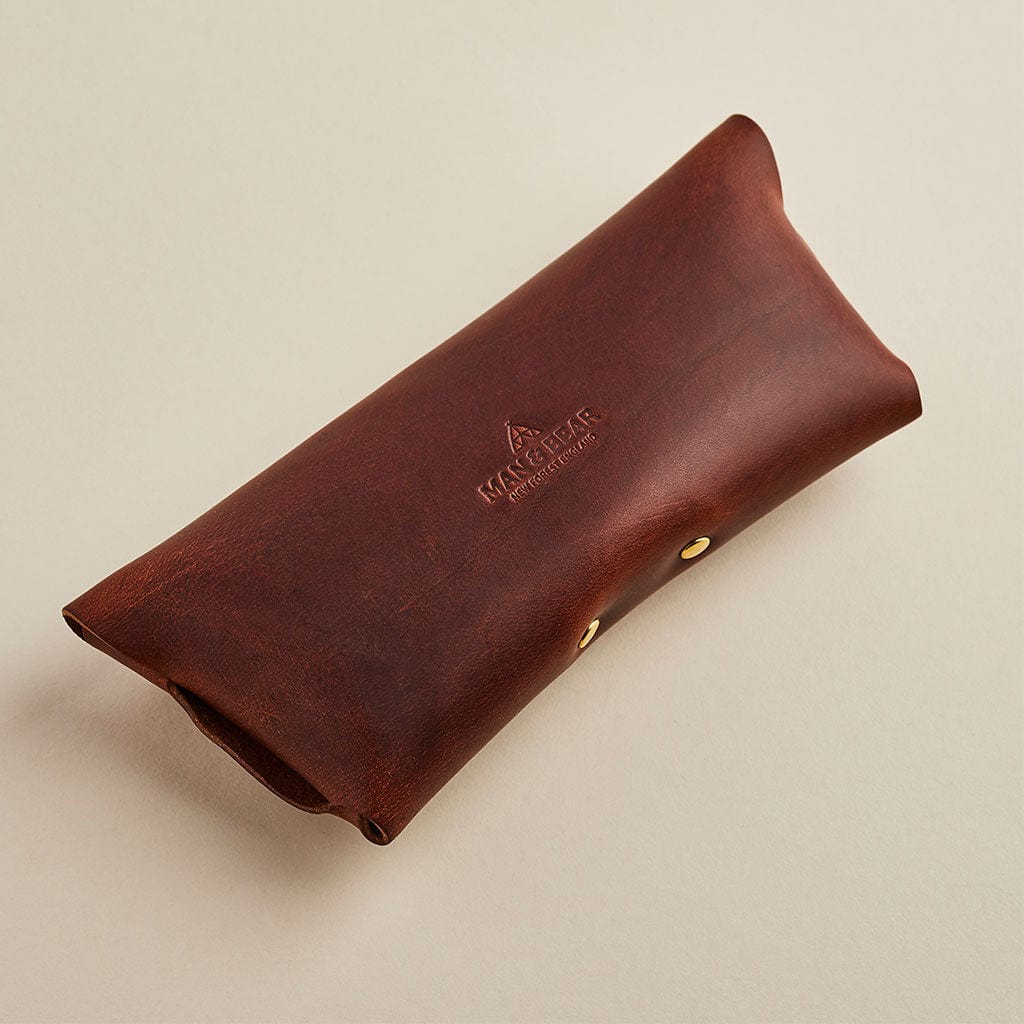 Brown leather glasses case showing the Man & Bear logo