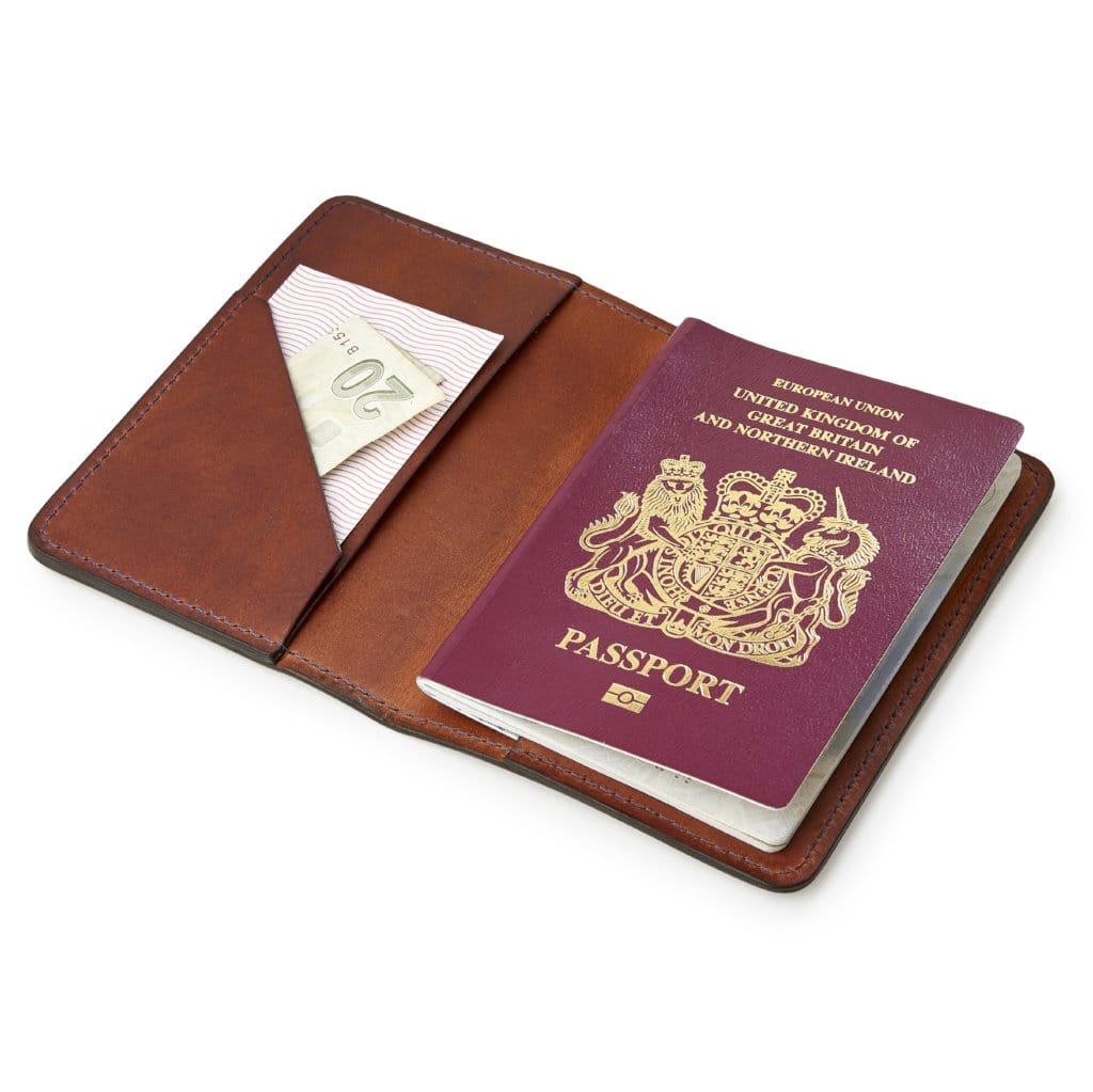 Brown leather passport holder by Man & Bear, shown with a British passport - cut out