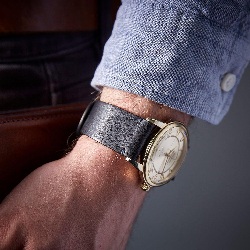 Men's wallet with black leather strap, modelled on a wrist