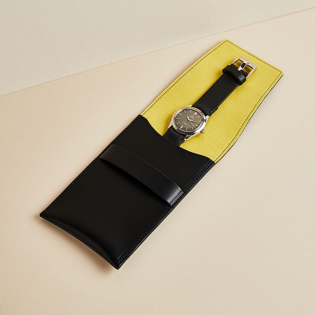 Black leather watch travel case with yellow lining by Man & Bear, shown with watch